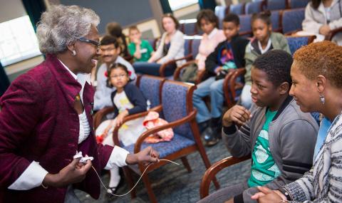 Dr. Valantine holds a catheter wire while talking with students in Wilson Hall.