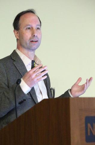 Dr. Shadlen speaks at podium.