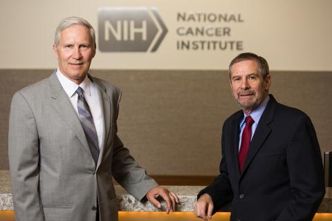 Schiller, Lowy stand in front of National Cancer Institute sign