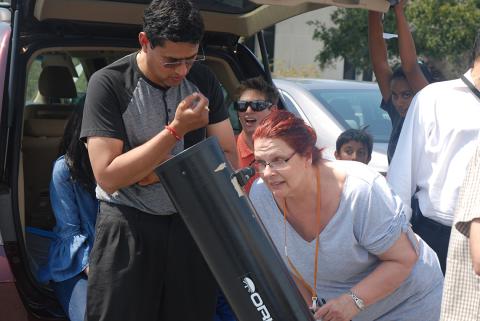 Iyer helps a woman use a telescope