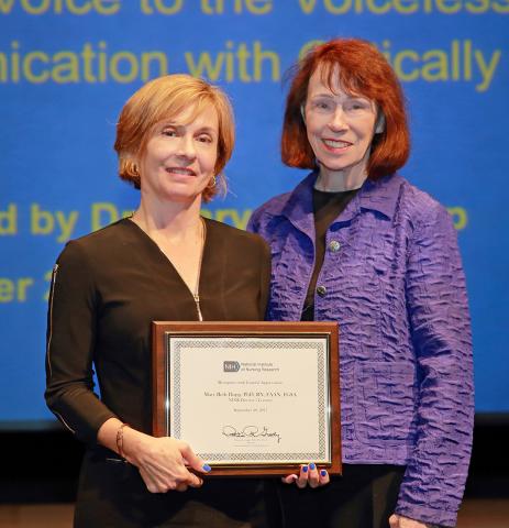 Dr. Mary Beth Happ holds plaque, poses with Dr. Grady 