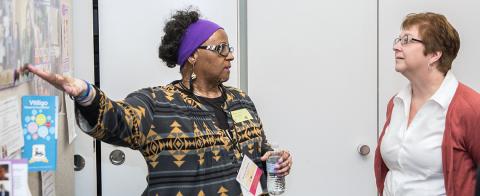 Participants discuss research poster during meeting