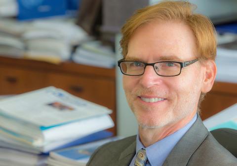A smiling Dr. Tromberg at his desk
