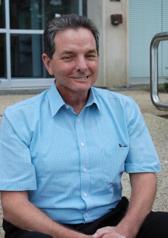 Kevin Sweeney, sitting outdoors on steps.