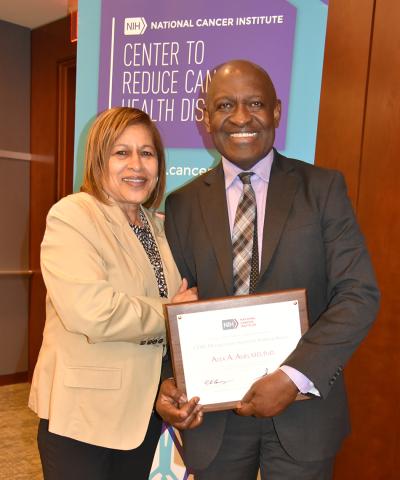 Dr. Springfield gives plaque to Dr. Adjei