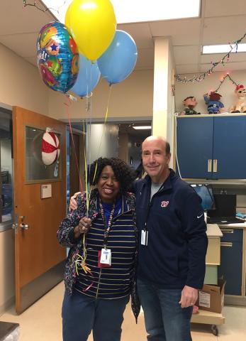 Sanders holds balloons while smiling with Gannon