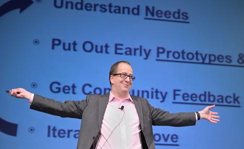 Eric Dishman smiles with outstretched arms as he explains the All of Us innovation process.