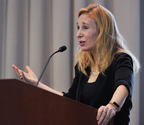 Dr. Sheena Josselyn with outstretched hand speaks at podium.