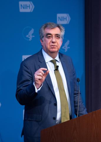 Collinge gestures while speaking at the podium