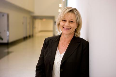 Bakaletz leans against a wall, smiling