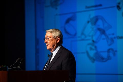 Cooper stands in front of a screen