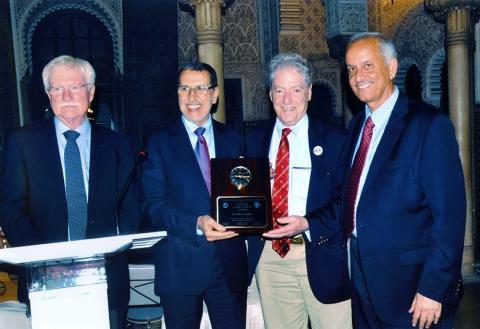 A smiling Dr. Gardner holds award, poses with NIAAA's Dr. Koob, the prime minister of Morocco and Dr. Ali of IDARS.