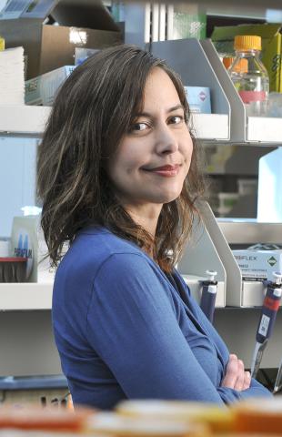 Smolke stands in her lab, surrounded by books, vials and medical gadgets