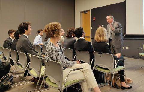 Tabak stands in front of classroom, addresses summer students