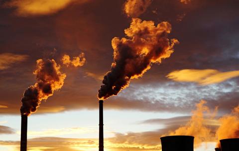 Smoke billows from power plant smokestacks.