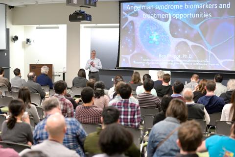 Philpot lectures with slide projected beside him and audience in foreground.