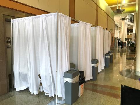 View of CRC main entry lobby with white sheets hanging from tall racks used to separate screening areas.