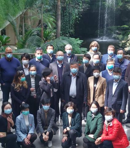 Group shot of people wearing masks covering nose and mouth.