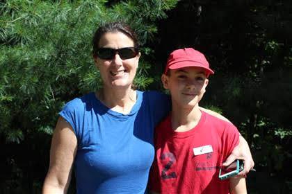 Thurm stands outside, hugging her son, with her smartphone in hand.