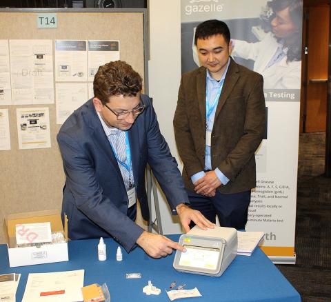 Two scientists examine device.