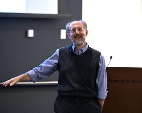 A smiling Dr. Giniger talks to the audience.