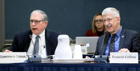Smiling, Tabak and Collins seated at conference table