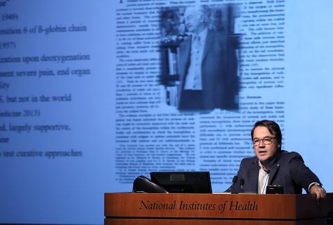 Dr. Tisdale speaks at podium in front of a research slide