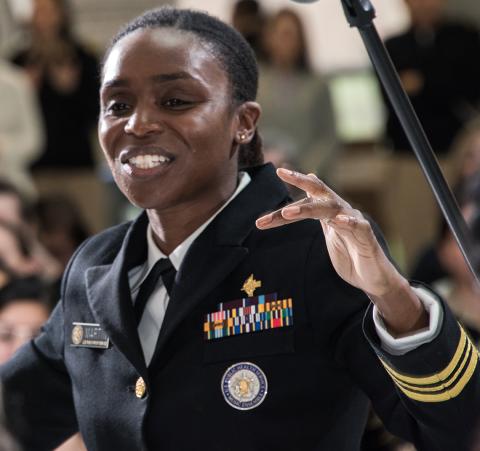 Standing in uniform, Lieutenant Commander Iman Martin conducts an ensemble.