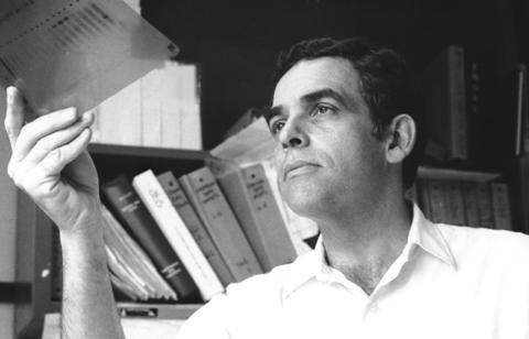 Leder, holding up and examining a slide