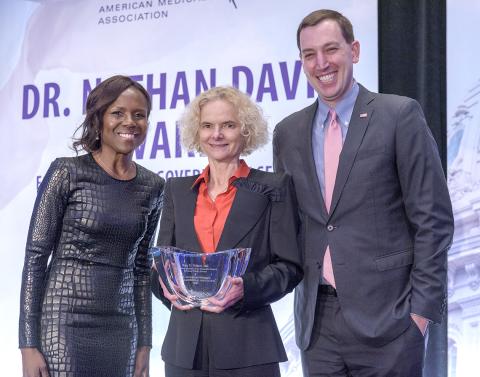 Volkow holds award flanked by Roberts and Ehrenfeld.