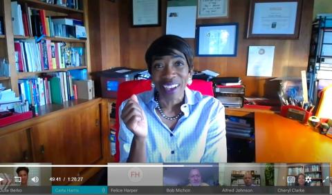 A smiling Harris sits at her desk talking to her videoconference audience
