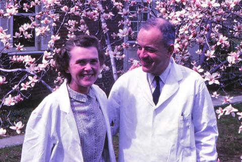 A photo from 1967 shows Herb and Celia Tabor together in their white lab coats in front of a cherry blossom tree.