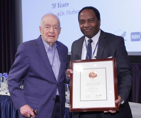Tabor with Dr. Rodgers, holding a framed letter of gratitude from former President Obama.