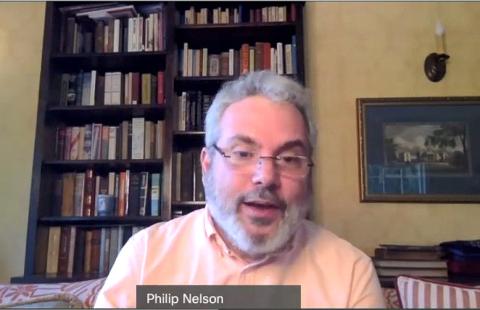 Google engineer Philip Nelson speaks on video from his home office, bookcases behind him.