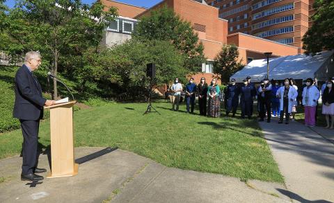 Collins speaks a group of employees while physically distanced