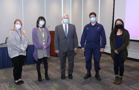Five animal care workers, in face masks, stand for photo.