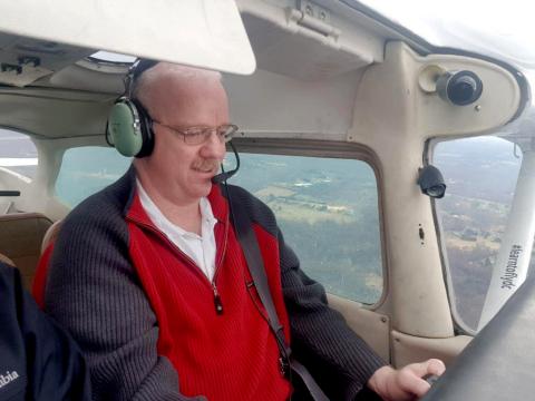 Dr. Michael Proschan, wearing headphones and mic, looks to be piloting a plane