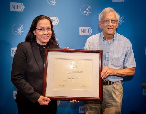 Quiroz and Hodes stand holding a plaque presented to her.