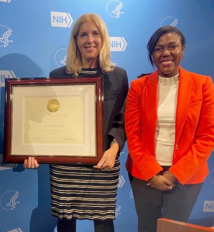 Vosshall holds a plaque and stands next to Joseph