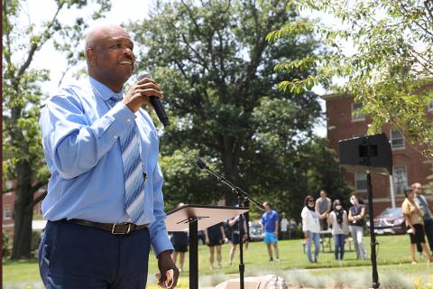 Johnson in suit and tie talks into microphone