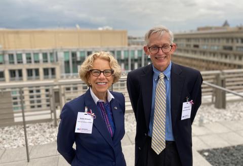 Bianchi and Lane stand smiling together outside on a rooftop on the NIH campus.