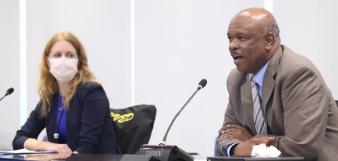 Schwetz looks on as Johnson speaks into mic.