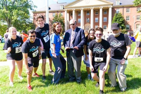 In front of Bldg. 1, McGowan and Tabak strike poses amid team runners.
