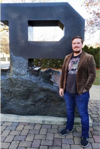 Rudakov stands in front of the Unfinished Block P statue on Purdue University's campus