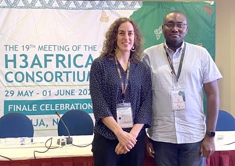 Dr. Bonnie Joubert and Kana stand together in front of their booth, in front of H3Africa backdrop.