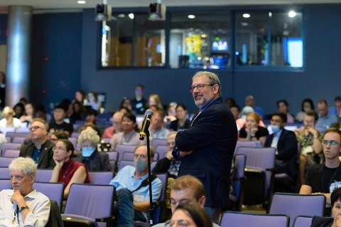 Gordon speaks at a microphone in the seats