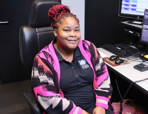 Neal smiles in her chair. 