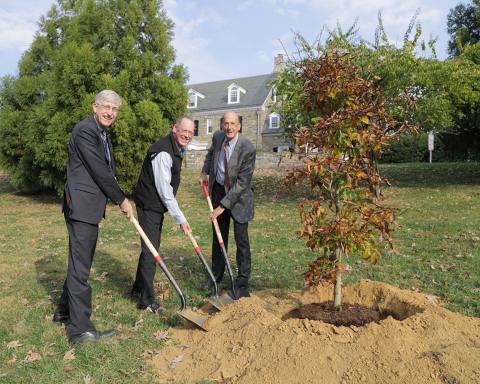 Collins, Farmer, and Glass, with shovels, smile into camera.