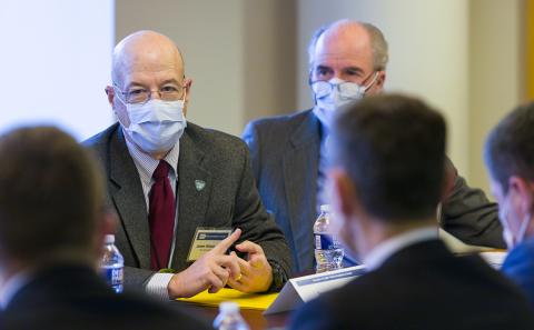 Gilman and Kilmarx, seated, talk with the minister.