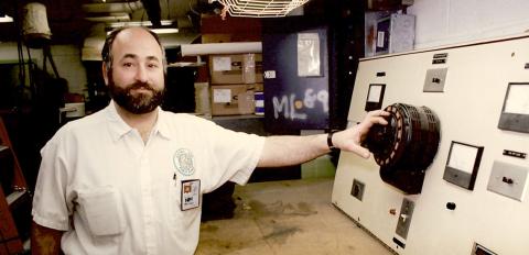 Salah in uniform with various devices and boxes behind him